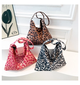Three leopard print tote bags in brown, red, and grey on white display steps