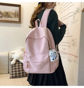 Detailed close-up of pink star pattern backpack with a cute white plush bear pendant