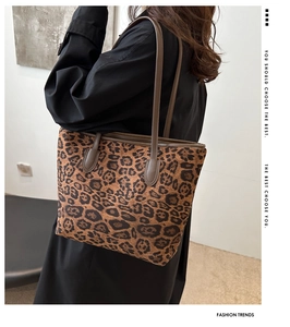 Detail showing high-capacity leopard print tote bag with brown leather shoulder straps