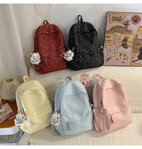 Detail shot of five colors of canvas star and moon backpacks with plush bear pendants
