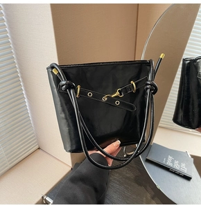 Détail d'un sac cabas noir brillant en similicuir avec garnitures en métal doré chic