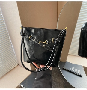 Détail du sac fourre-tout en similicuir noir avec boucle dorée et anse nouée