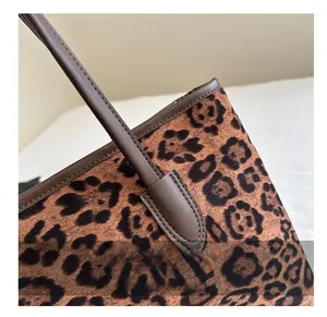 Close-up of leopard print tote bag detailing textured fabric and brown leather stitching