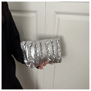 Close-up of metallic silver quilted clutch bag with stylish puffed pleated texture