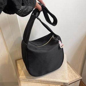 Sac à bandoulière noir minimaliste en forme de croissant avec pendentif de dessin animé