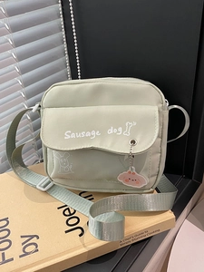 Cute green crossbody nylon bag featuring a sausage dog print and lovely metal charm