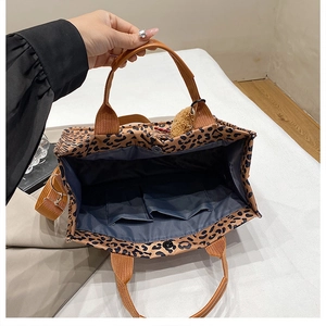 Macro view of leopard print tote bag interior featuring double pockets and blue lining