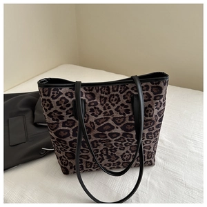 Detail of leopard print tote bag featuring horsehair texture and black leather straps