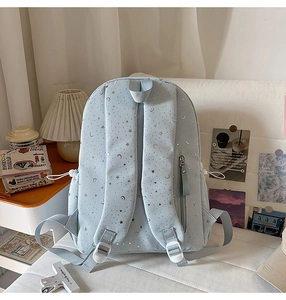 Detail view of light blue star print backpack with adjustable padded straps and side pockets