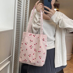 Borsa tote in velluto a coste rosa con stampa di ciliegie in un selfie allo specchio