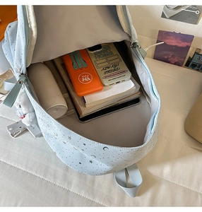 Detail showing high capacity storage of the light blue star pattern backpack with books