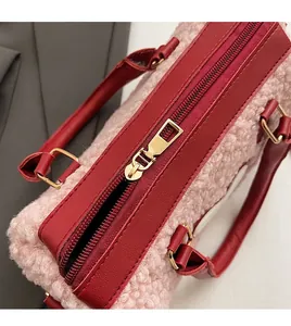 Detailaufnahme des glatten goldenen Metallreißverschlusses der pinkfarbenen Plüschhandtasche