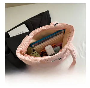 Pink quilted tote bag with bow detail showing large capacity for tablet and umbrella
