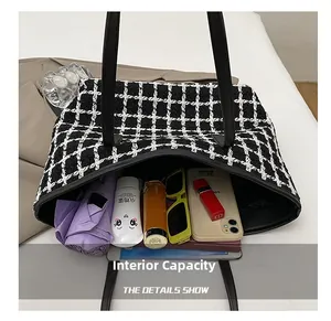 Vista macro della grande borsa tote che mostra l'interno spazioso e il tweed bianco e nero