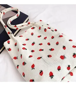 Dettaglio della borsa tote in velluto a coste bianco crema con stampa di fragole
