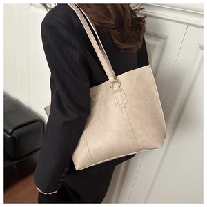 Detail of beige textured faux leather tote bag with gold ring and Fashion logo