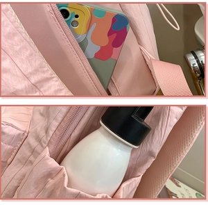Detail of pink backpack side pockets showing phone storage and water bottle holder
