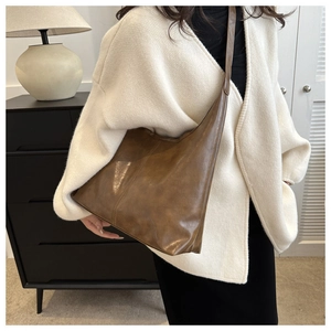 Brown vintage large capacity tote bag shown on model with wide shoulder strap