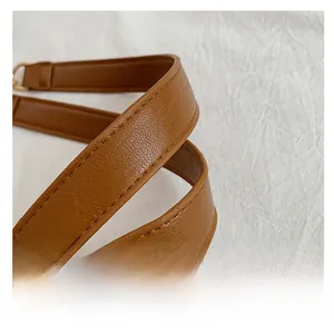 Détail de la poignée en cuir PU marron avec grain de litchi et anneau en métal doré