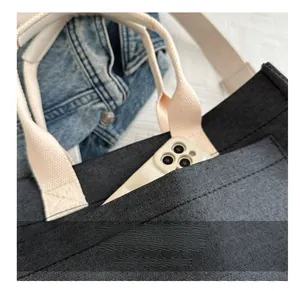 Détail du sac cabas en toile gris foncé avec une poche avant pour ranger un smartphone