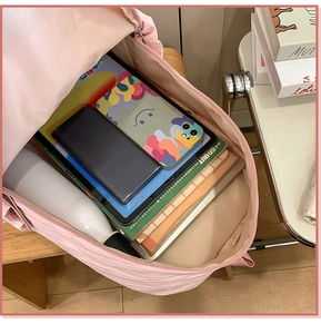 Pink travel backpack showing organized spacious interior with tablet and water bottle