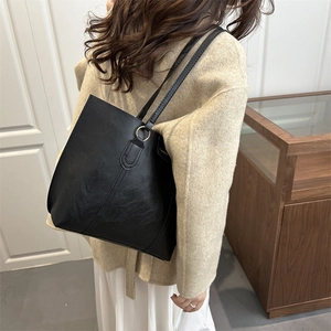 Large black textured leather tote bag for women with gold rings and V-stitch detail