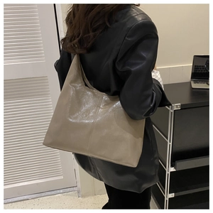 Detailed view of taupe large capacity oil-wax leather tote bag on a model shoulder