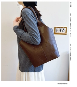 Detail of vintage brown leather tote bag with geometric patchwork stitching on model