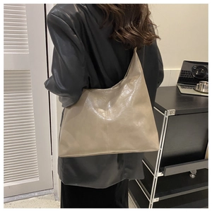 Close-up of beige minimalist tote bag showing soft faux leather texture and large capacity