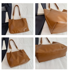 Vue détaillée montrant la texture et la bandoulière chaîne du sac cabas en cuir marron
