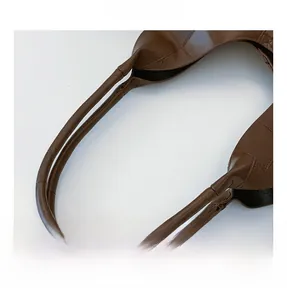 Close-up of crocodile textured tote bag handle with brown leather and stitched detail