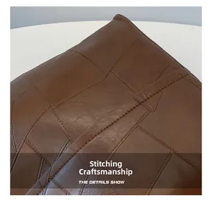 Close-up of precise stitching and geometric leather patchwork on the brown tote bag