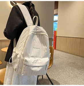 Detail showing the fashionable pleated texture on white lightweight travel backpack
