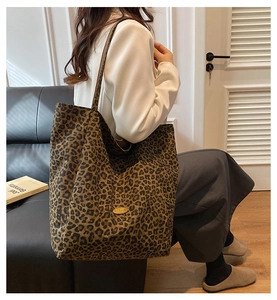 Detailed view of the leopard print canvas tote bag with elegant golden metal brand plate