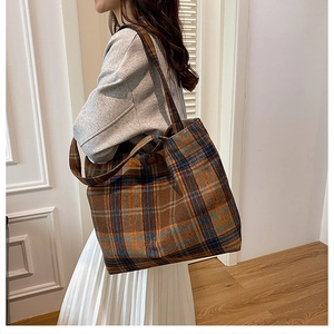 Macro view of plaid tote bag texture showing warm wool fabric and vintage pattern