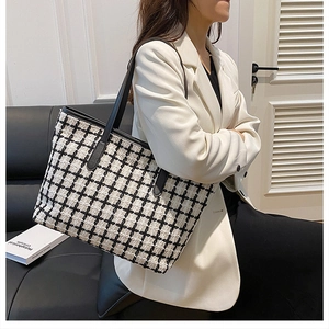 Dettaglio della borsa tote a scacchi in tweed con tracolle in pelle nera su modella