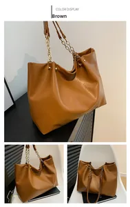 Vue détaillée du sac cabas marron en cuir souple avec chaîne dorée et rivets en métal
