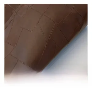 Detail of dark brown leather texture with geometric patchwork embossed pattern