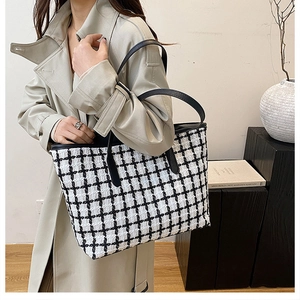 Dettaglio della borsa tote a scacchi con motivo tweed bianco e nero e lunghi manici in pelle