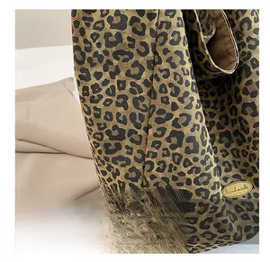 Detailed macro view of leopard print canvas fabric with a handmade golden metal label