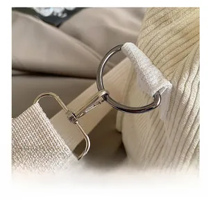 Close-up of durable silver metal hook and corduroy fabric stitching on tote bag