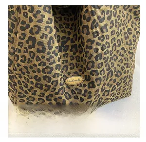 Detail of leopard print canvas fabric with a golden handmade metal buckle on a tote bag