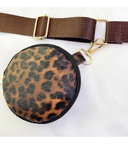 Detail of round leopard print coin purse with adjustable brown nylon shoulder strap