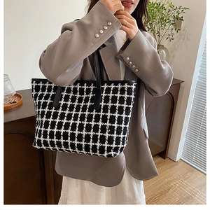 Dettaglio di una grande borsa tote in tweed a quadri bianchi e neri con manici in PU