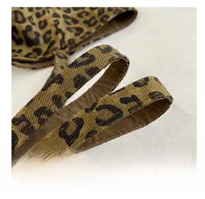 Close-up of leopard print tote bag shoulder strap with reinforced canvas and brown lining