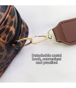 Detail of detachable gold hardware hook and leopard print texture on a travel makeup bag