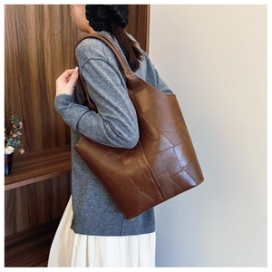 Detail of the vintage brown patchwork tote bag showing textured geometric leather panels