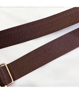 Detail of adjustable dark brown nylon shoulder strap with gold metal buckle