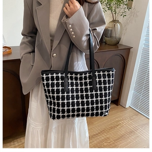Elegante borsa tote in tweed a quadri con manici in pelle in un ambiente raffinato