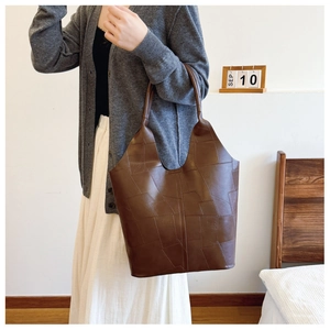 Brown textured tote bag shown on shoulder in a minimalist vintage lifestyle setting